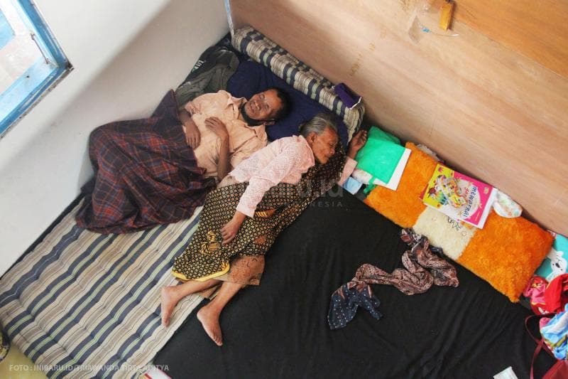 Dua pengungsi lanjut usia terlelap di bilik pengungsian Desa Banyurojo, Kabupaten Magelang. Satu petak bilik pengungsi biasanya diisi oleh dua keluarga.<br>