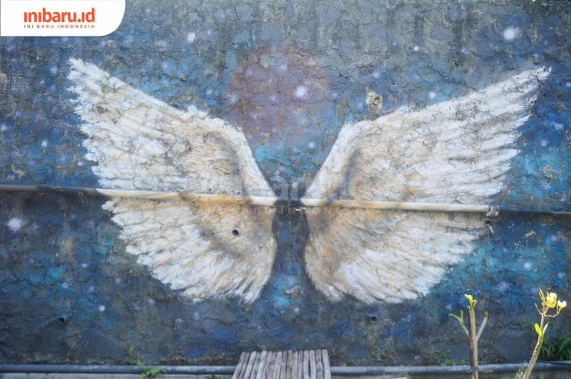 Sepasang sayap yang digambar di dinding; satu dari dua spot foto instagenik di  dekat kolam. (Inibaru.id/ Kharisma Ghana Tawakal)