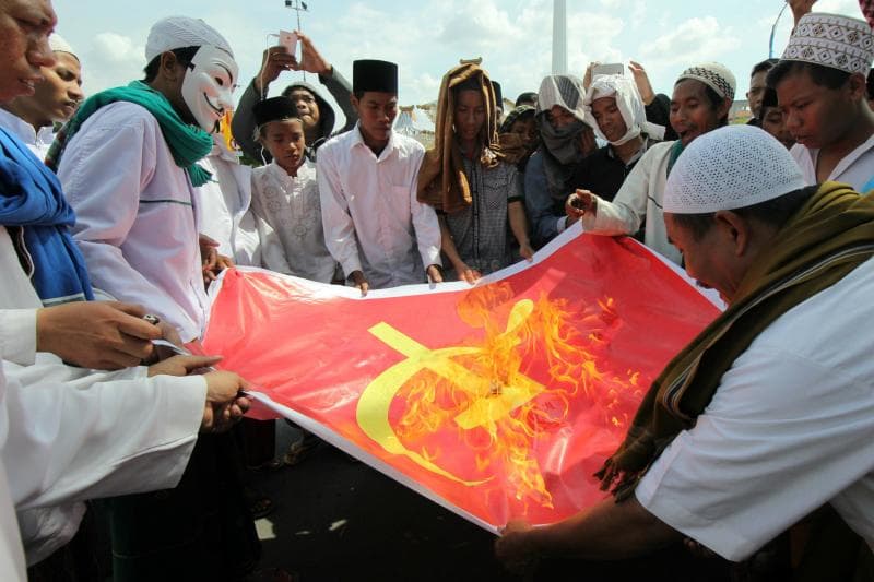 Ilustrasi: Massa Front Pembela Islam (FPI) dan Front Pancasila membakar kain bersimbol partai komunis di depan Kantor Gubernur Jawa Timur, Surabaya. (Tirto/Antara Foto/Didik Suhartono)
