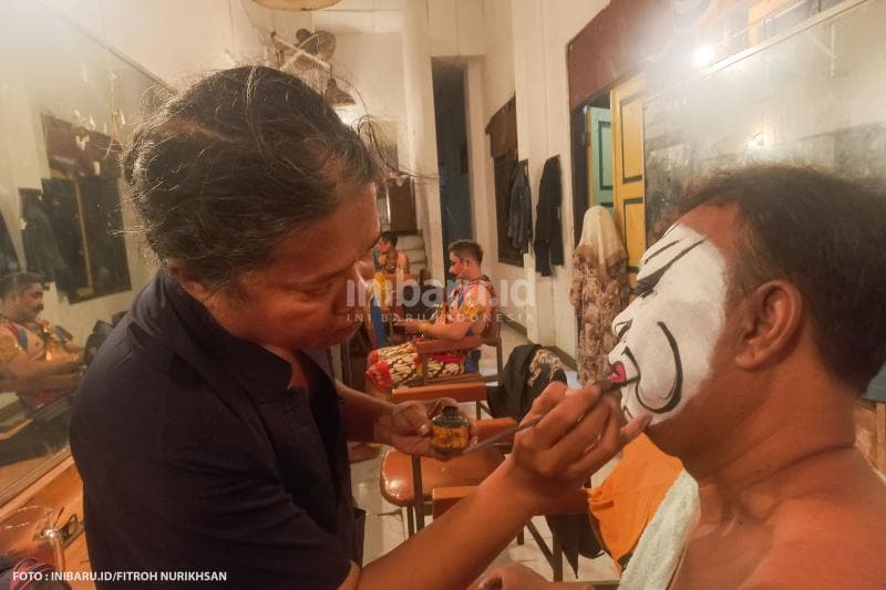 Sesama anggota wayang orang Ngesti Pandowo saling membantu merias wajah sebelum tampil.