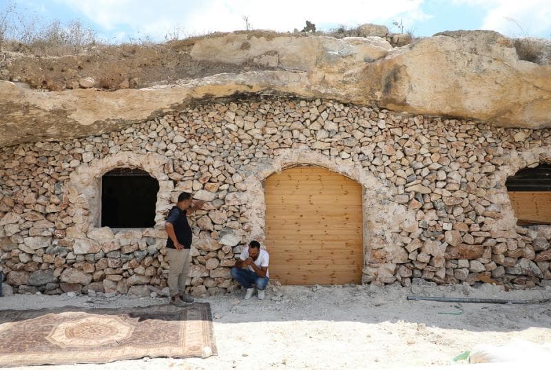Mulut gua ditutup dengan batu dan diberi pintu kayu untuk menjadi rumah bagi&nbsp;Ahmed Amarneh dan keluarganya. (AFP/Jaafar Ashtiyeh)